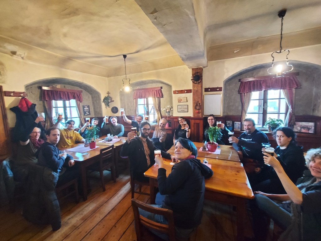 Eine Gruppe Menschen hebt die Gläser in einer altmodischen gaststube